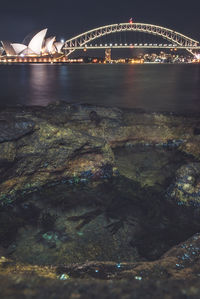 Illuminated bridge over river at night