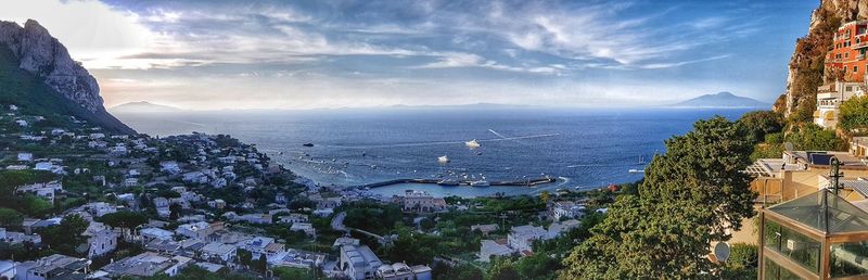 High angle view of city by sea against sky