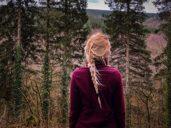 Woman with braided hair standing in forest