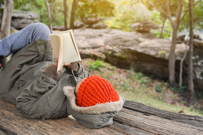 High angle view of boy reading book while lying on wood
