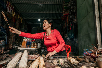 Smiling mid adult woman selling food in store