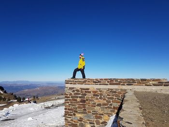 Man standing against blue sky