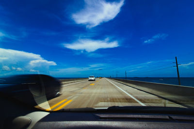 Road against sky seen through car windshield