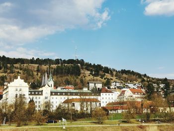 Houses and buildings in town against sky