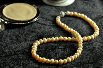 High angle view of pearl jewelry on textile