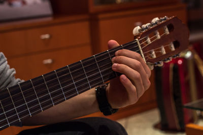 Cropped hand of man playing guitar