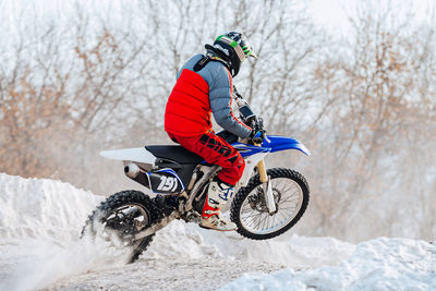 Man riding bicycle on snow covered field