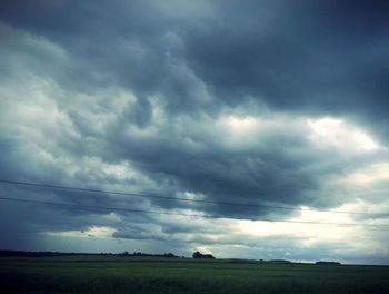 Scenic view of field against storm clouds