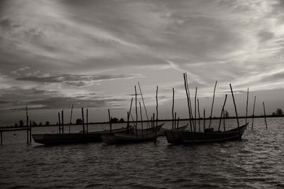 Boats moored on sea against sky during sunset