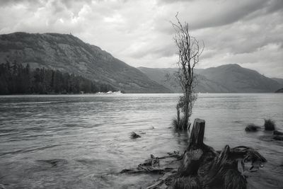 Scenic view of lake by mountains against sky