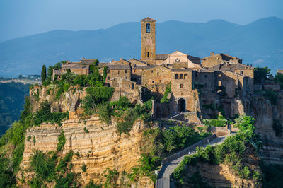 Old building by mountain against sky