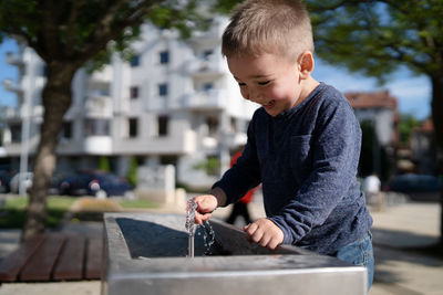 Cute boy drinking water at fountain