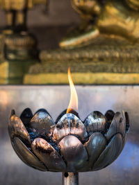 Close-up of burning oil candle in buddhist temple, chiang mai, thailand