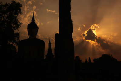 Low angle view of silhouette statue against sky during sunset