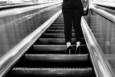 Low angle view of woman standing on escalator