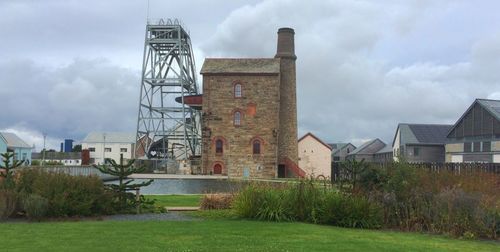 Built structure on landscape against cloudy sky