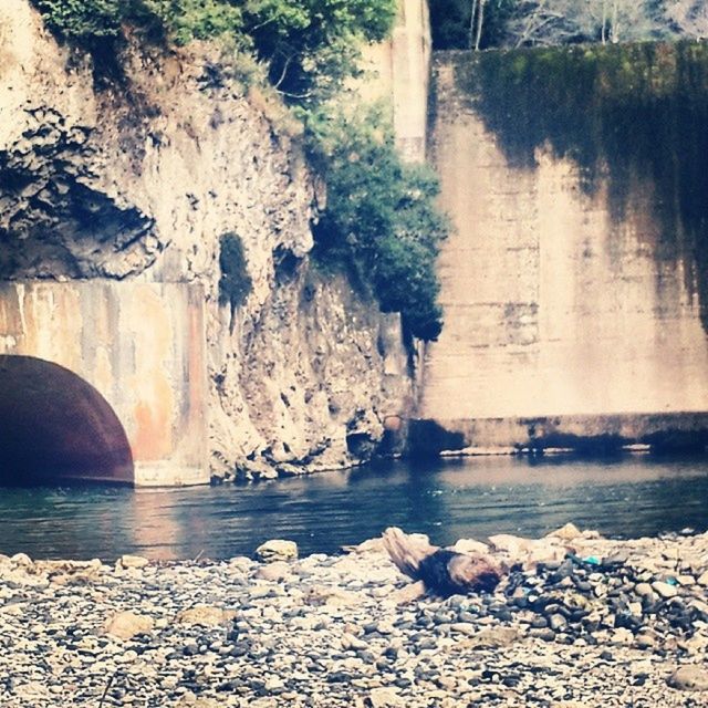 water, rock - object, tree, nature, stone - object, beauty in nature, river, tranquility, rock, scenics, rock formation, tranquil scene, reflection, day, built structure, stone, outdoors, no people, flowing water, lake