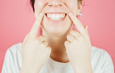 Portrait of young woman against yellow background