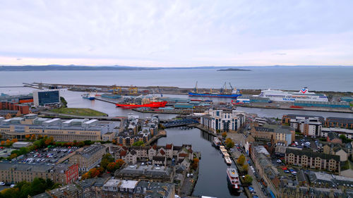 High angle view of cityscape by sea against sky