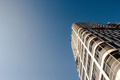 Low angle view of skyscraper against clear blue sky