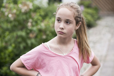 Angry girl with hands on hips looking away outdoors