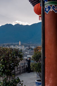 Rear view of people looking at mountains against sky