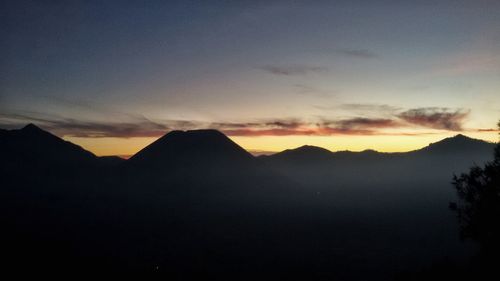 Scenic view of silhouette mountains against sky at sunset