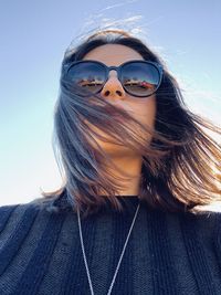 Portrait of woman wearing sunglasses against sky