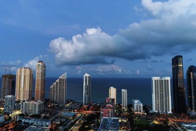 Modern buildings in city against cloudy sky