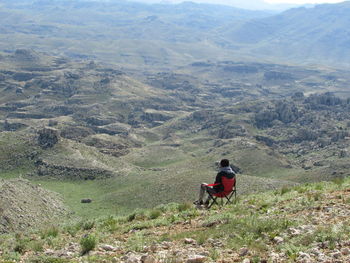 Rear view of man sitting on landscape