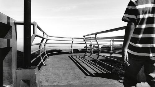 Man on railing against sky