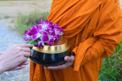 Close-up of hand holding purple flower