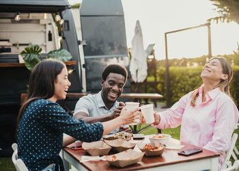 Female friends using mobile phone while sitting at restaurant