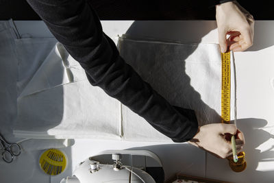 Top view of crop sewer with measuring tape and fabric on a table