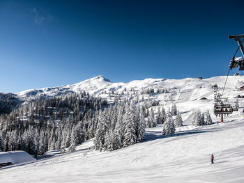 Scenic view of snow covered mountains against clear blue sky