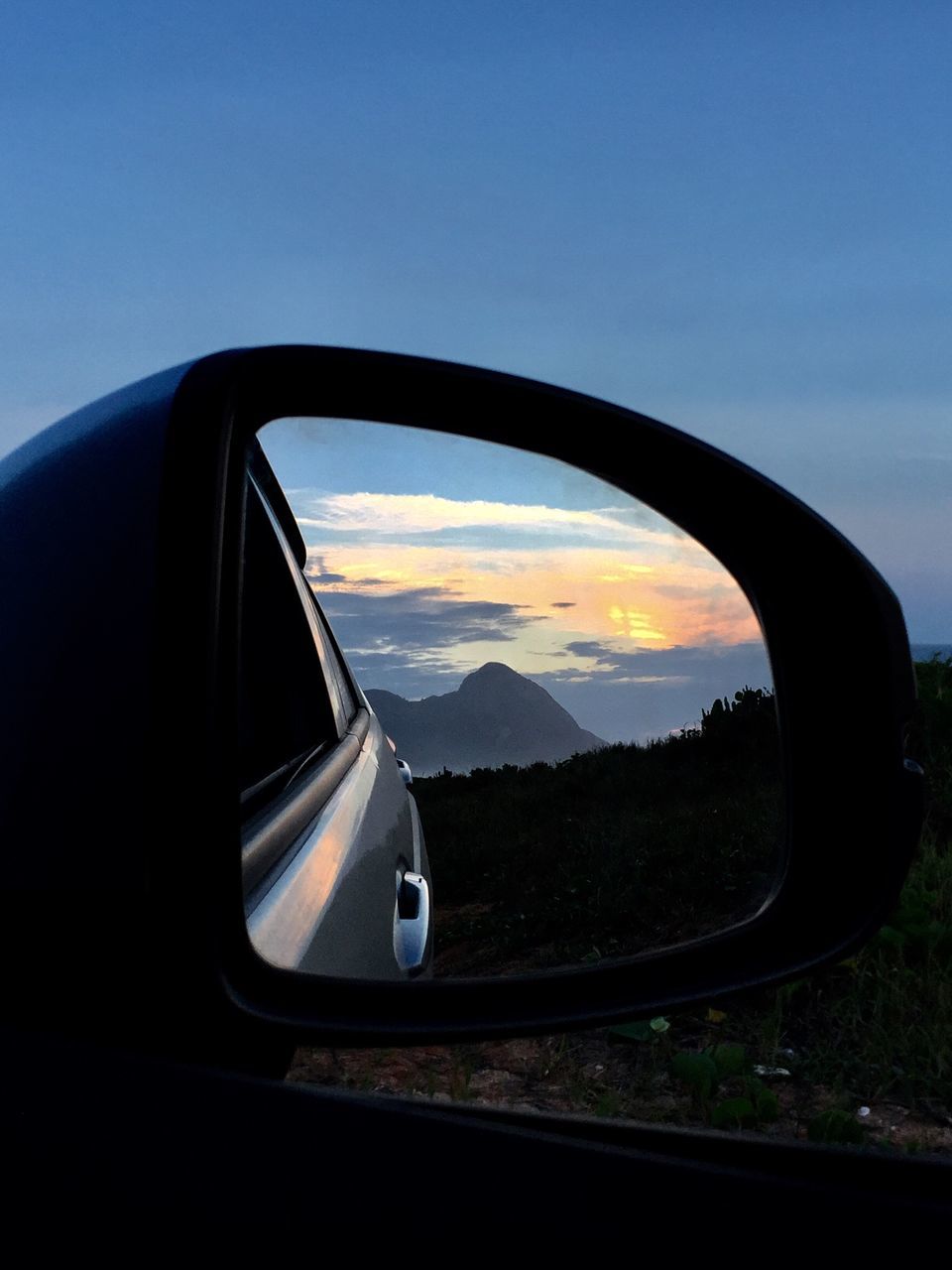 car, sky, transportation, sunset, no people, road, side-view mirror, outdoors, mountain, close-up, vehicle mirror, day