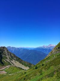 Scenic view of mountains against clear blue sky