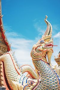 Low angle view of statue against temple building against sky