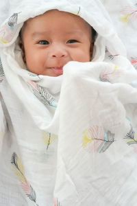 Portrait of cute baby lying on bed