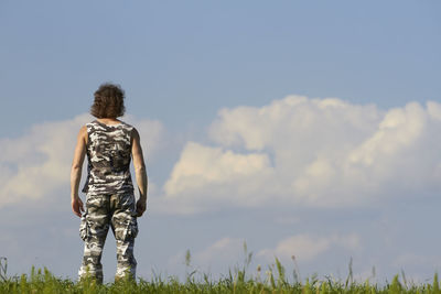 Rear view of woman standing against sky