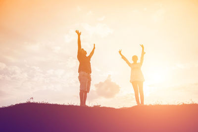 Low angle view of silhouette woman standing against sky during sunset