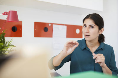 Mid adult businesswoman discussing with colleague in office