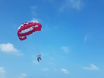 Low angle view of person paragliding against sky