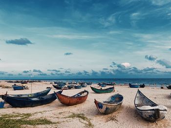 A group of boats are parked on the beautiful yellow sand beach.