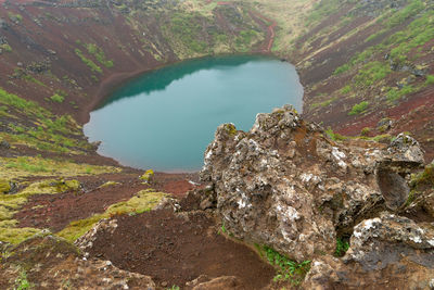 High angle view of crater lake amidst rocks