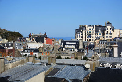 Buildings in city against clear blue sky