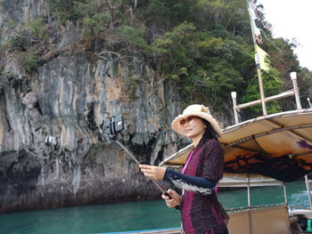 Woman taking selfie while standing on boat