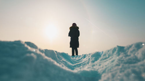 Man standing on snow covered mountain against sky