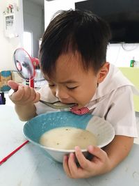 Close-up of boy eating breakfast at home