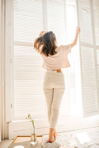 Rear view of woman standing at home